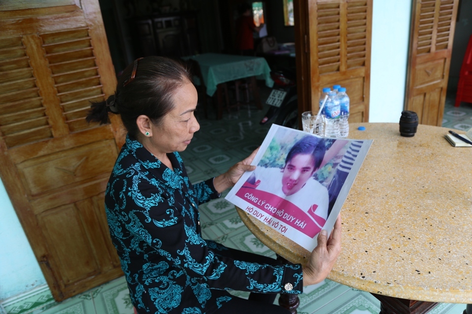 Bà Nguyễn Thị Loan, mẹ của Hồ Duy Hải, cầm tấm biểu ngữ kêu oan cho con. Ảnh: vnntoday.vn.